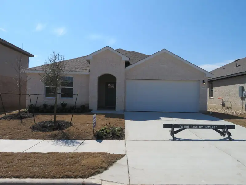 Front exterior of a new home in Bar W Ranch, Leander, TX, highlighting curb appeal (Image 1).