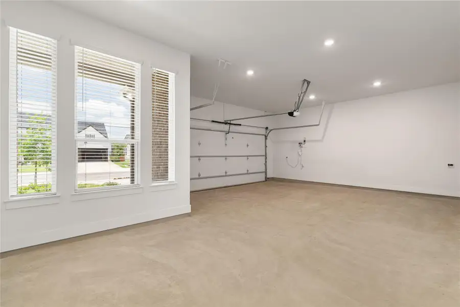 A spacious and pristine garage provides ample parking and storage with multiple windows allowing natural light. A spacious and pristine garage provides ample parking and storage with multiple windows allowing natural light.