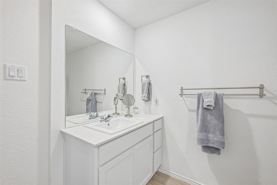 Modern bathroom featuring a white vanity with shaker-style cabinetry, an integrated rectangular sink, and a large wall-mounted mirror Modern bathroom featuring a white vanity with shaker-style cabinetry, an integrated rectangular sink, and a large wall-mounted mirror