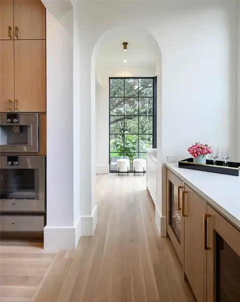 Doorway featuring wood finished floors, arched walkways, beverage cooler, and recessed lighting Doorway featuring wood finished floors, arched walkways, beverage cooler, and recessed lighting