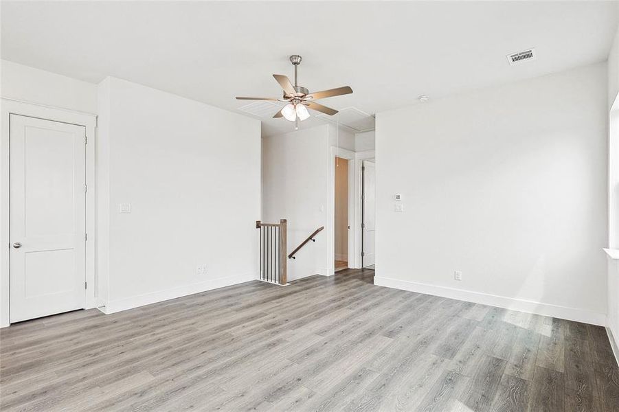 Empty room featuring light hardwood / wood-style flooring and ceiling fan