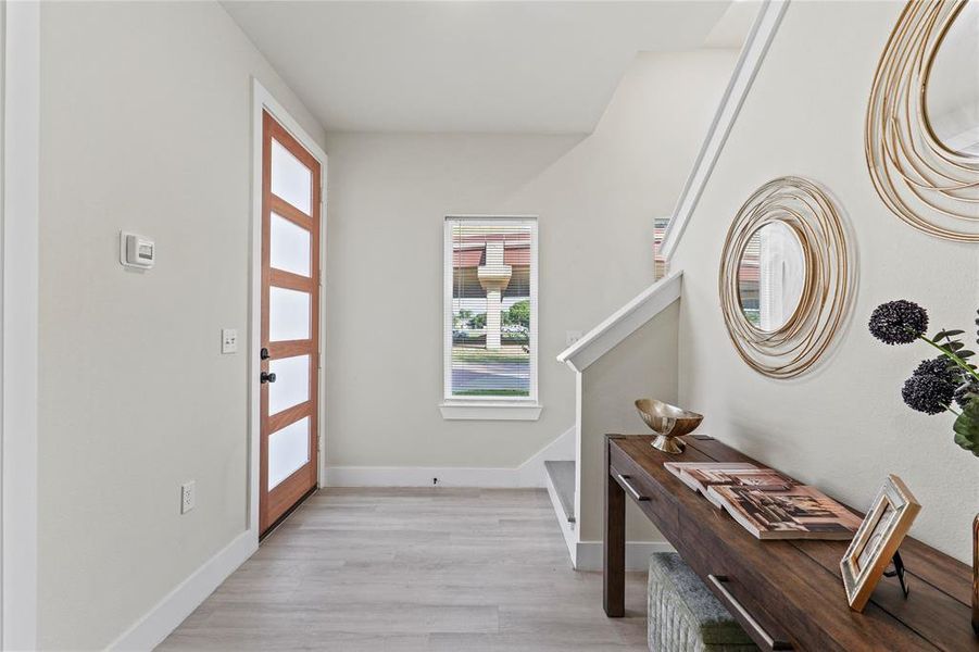 Entrance foyer with baseboards and light wood-style floors