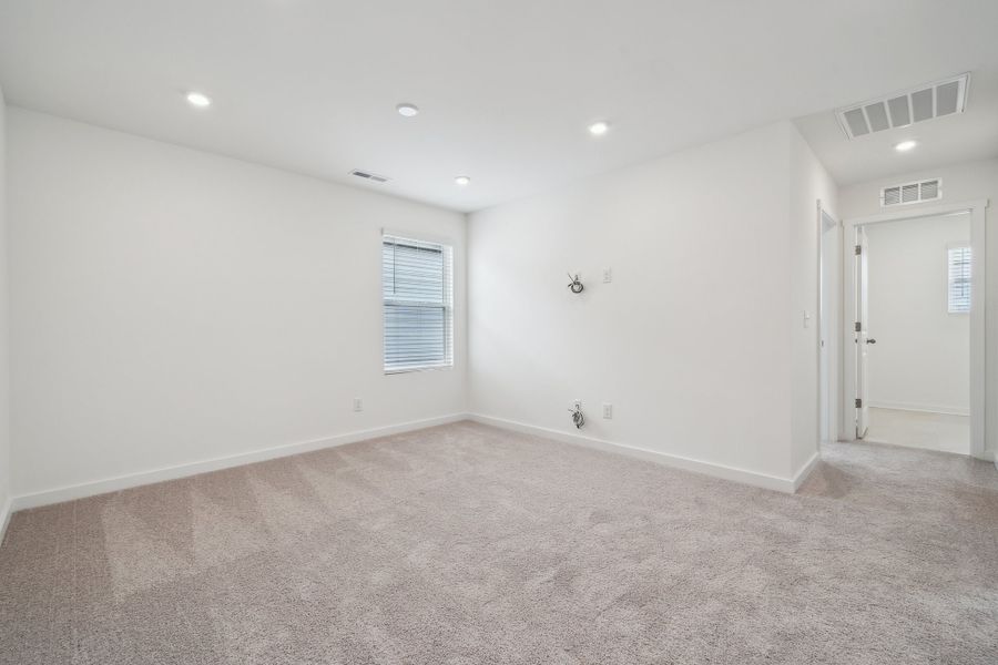 A room with a carpet and a door.