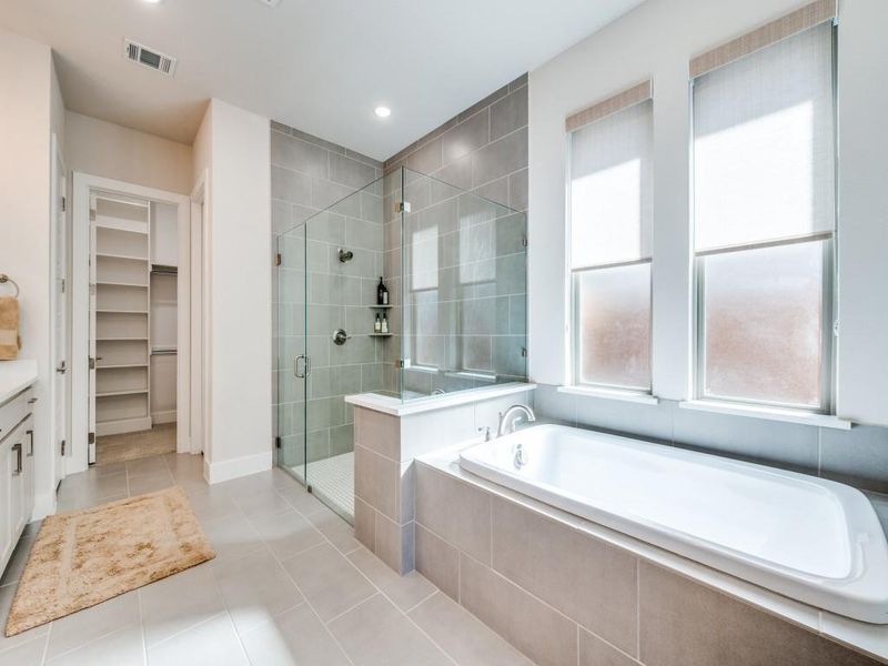 Bathroom with a stall shower, tile patterned flooring, a bath, a walk in closet, and recessed lighting