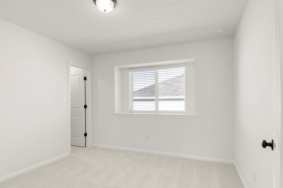 Empty room featuring light colored carpet and baseboards