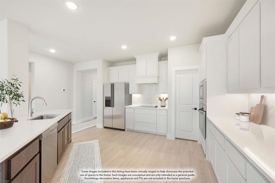 Kitchen with white cabinets, herringbone tile backsplash, stainless steel appliances, and light wood floors