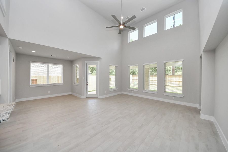 Relax and unwind in this inviting family room, illuminated by abundant natural light streaming in through tall windows, complemented by high ceilings and stunning flooring. Stay comfortable year-round with the gentle breeze from the ceiling fan, creating the perfect atmosphere for family gatherings. Relax and unwind in this inviting family room, illuminated by abundant natural light streaming in through tall windows, complemented by high ceilings and stunning flooring. Stay comfortable year-round with the gentle breeze from the ceiling fan, creating the perfect atmosphere for family gatherings.