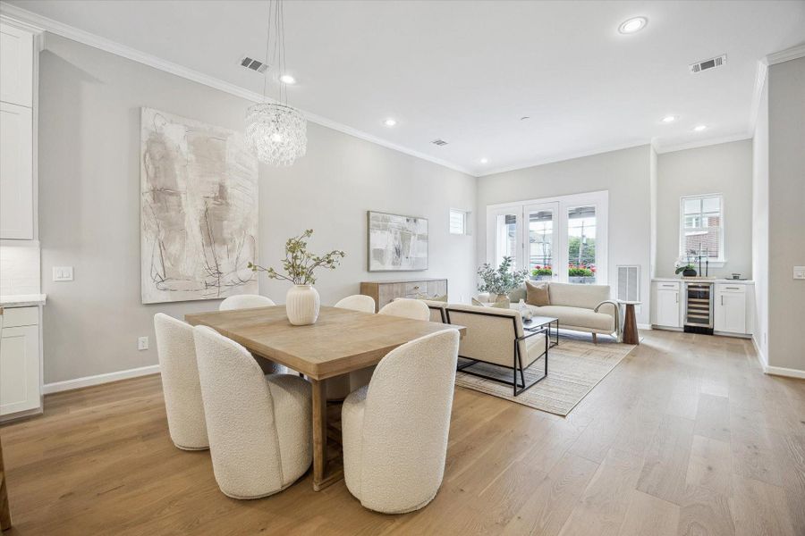 Dining area featuring a designer chandelier and recessed lighting.