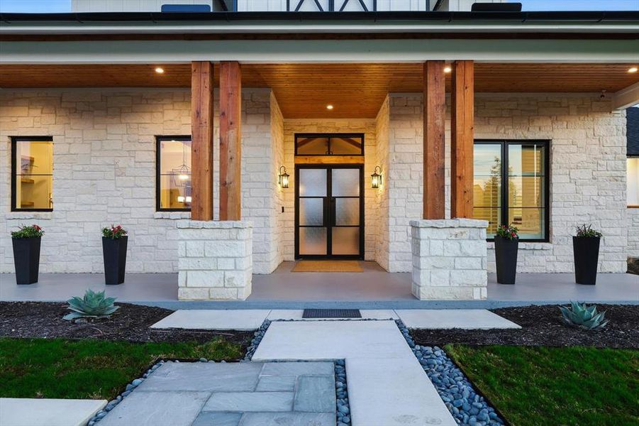 Doorway to property featuring covered porch and stone siding Doorway to property featuring covered porch and stone siding