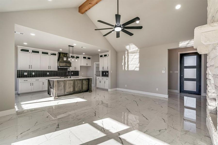 Kitchen with custom exhaust hood, a ceiling fan, and marble finish floor