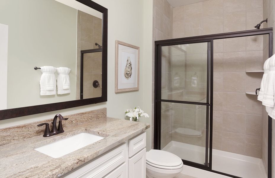 Guest Bathroom with a bronze finished walk-in shower.
