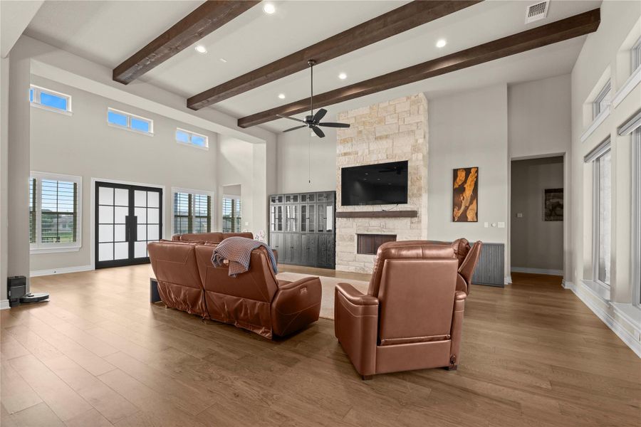 A well-lit great room features rich wooden beams and a striking stone fireplace. A well-lit great room features rich wooden beams and a striking stone fireplace.