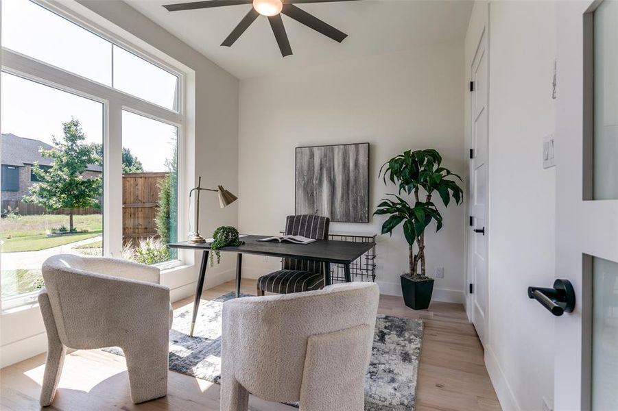 Home office featuring ceiling fan, a healthy amount of sunlight, and light wood-type flooring