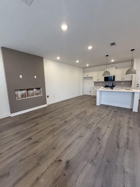 Unfurnished living room with dark wood-style floors and recessed lighting
