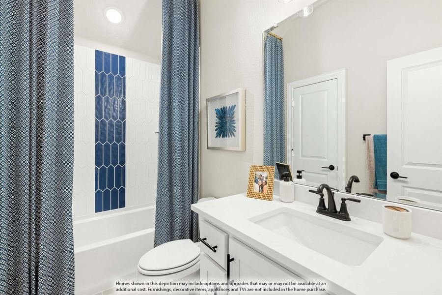 Bathroom with white vanity, black fixtures, and tub-shower with blue accent tile and patterned curtain Bathroom with white vanity, black fixtures, and tub-shower with blue accent tile and patterned curtain