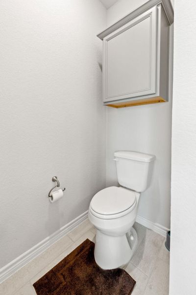 Bathroom with baseboards and light tile patterned floors
