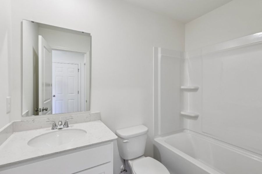 A bathroom with a sink toilet and bathtub.