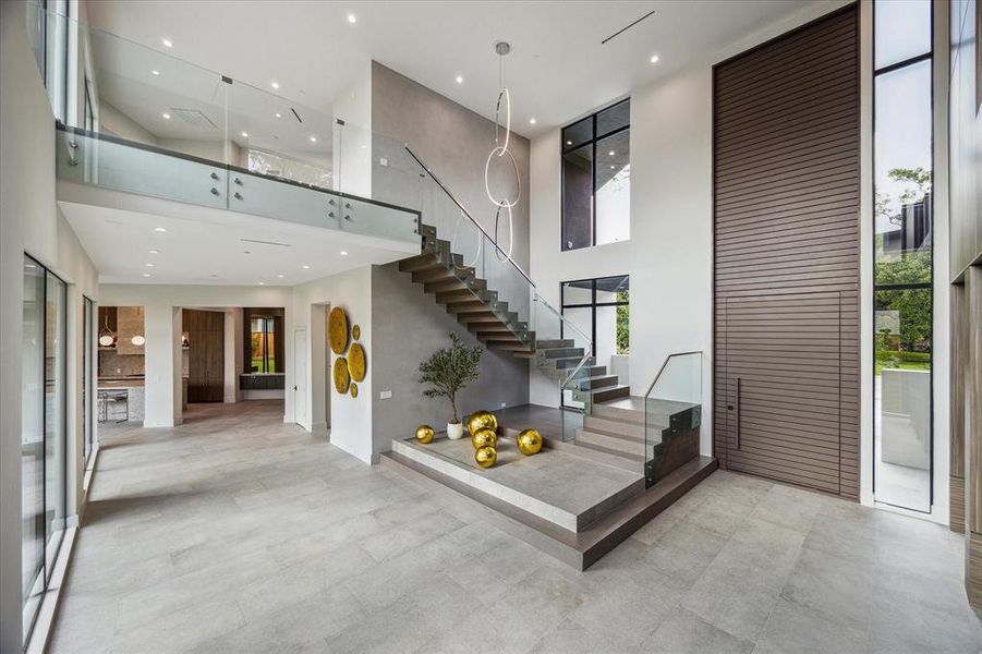 Ascend to the second floor via the floating white oak and steel stairs with glass and steel railings, or take the Inclinator elevator, to discover four additional bedrooms, a game room, and a utility room.