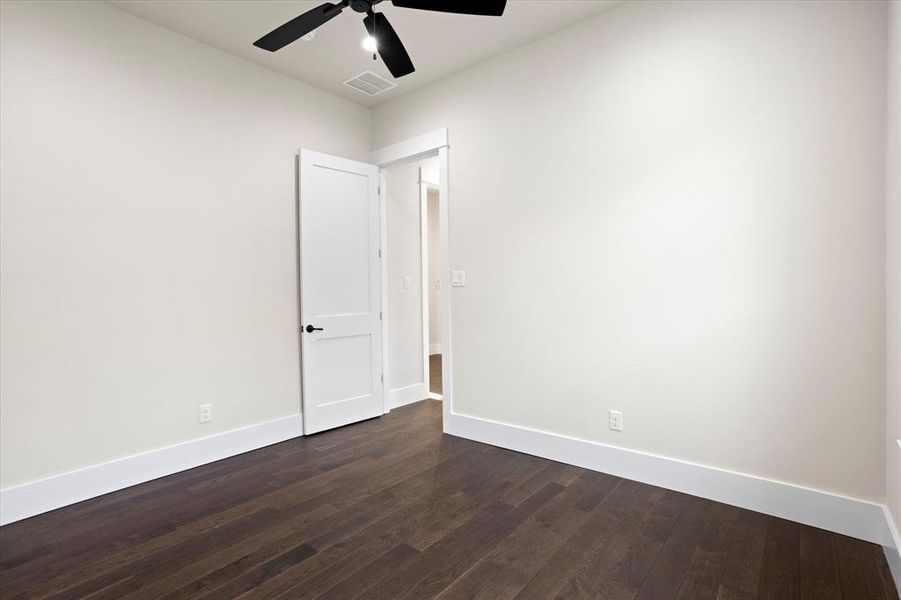 Unfurnished room with dark hardwood / wood-style flooring and ceiling fan