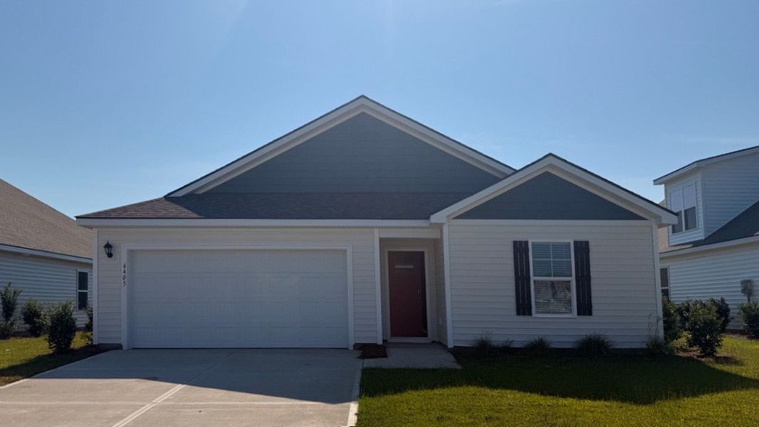 Front exterior of a new home in The Meadows at Wildwood Village, Shallotte, NC, highlighting curb appeal (Image 1). Front exterior of a new home in The Meadows at Wildwood Village, Shallotte, NC, highlighting curb appeal (Image 1).