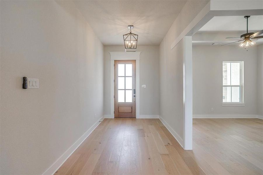 Doorway featuring baseboards, light wood-type flooring, and plenty of natural light Doorway featuring baseboards, light wood-type flooring, and plenty of natural light