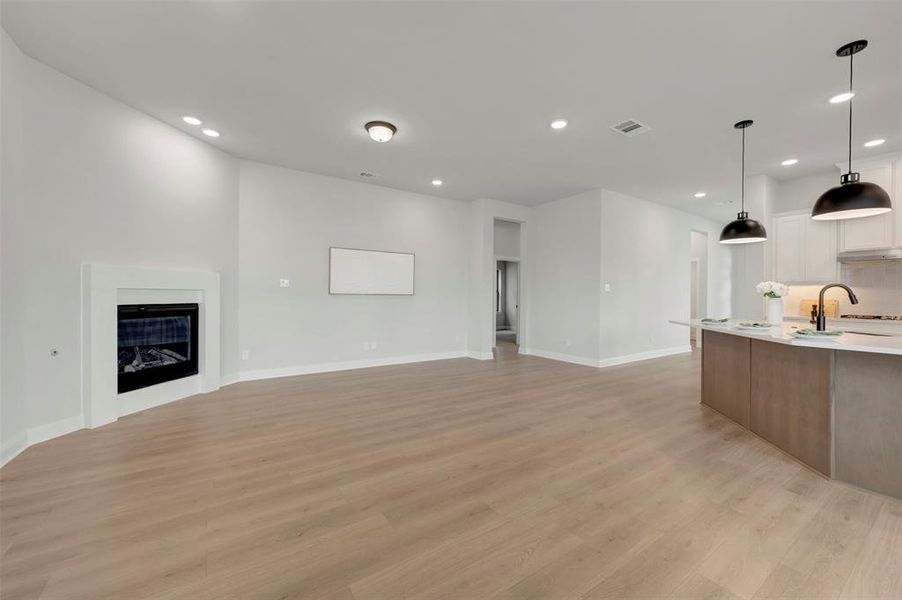 Unfurnished living room featuring recessed lighting, a fireplace, and light wood finished floors