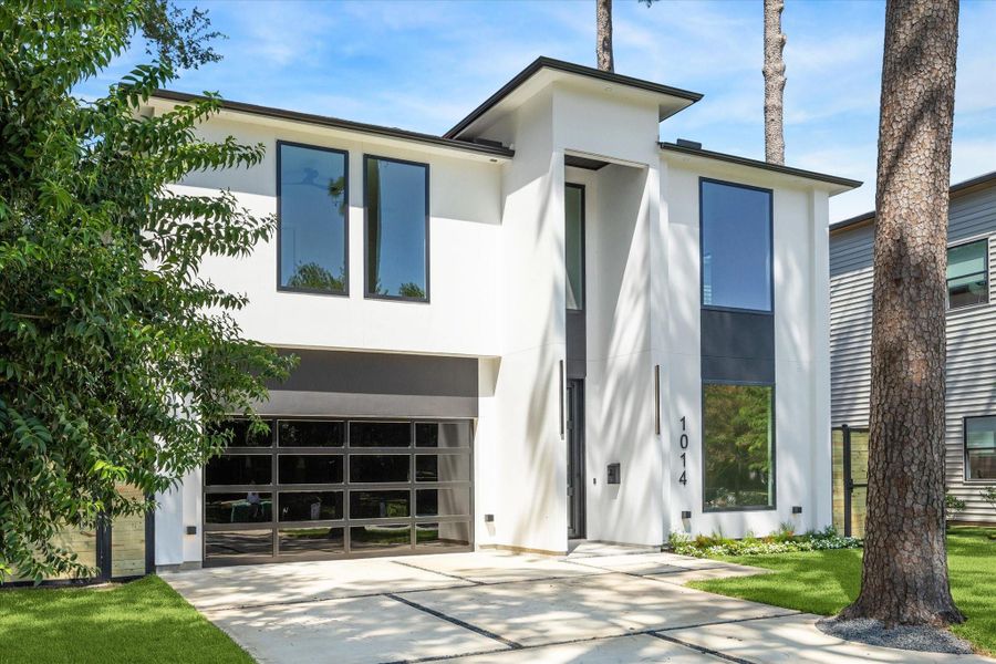 Tucked into the Garden Oaks neighborhood, among mature trees, the carefully curated exterior features bold curb appeal with its sleek façade, dramatic windows, and landscaped grounds. Tucked into the Garden Oaks neighborhood, among mature trees, the carefully curated exterior features bold curb appeal with its sleek façade, dramatic windows, and landscaped grounds.