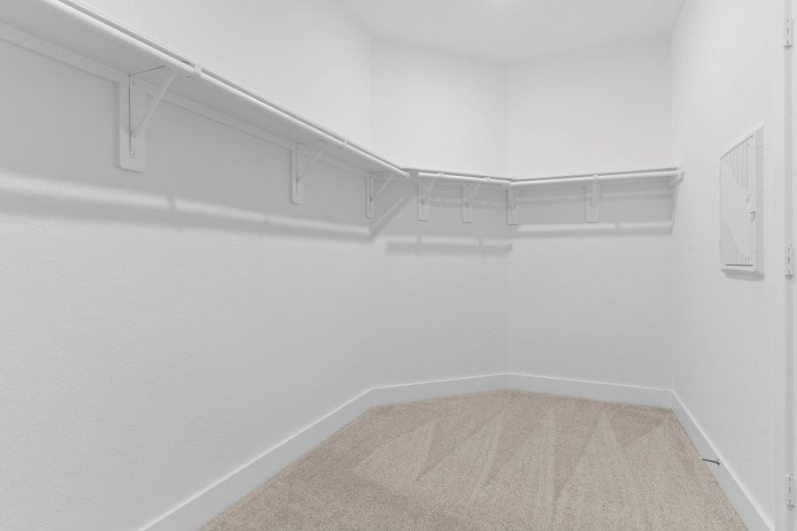Expansive walk-in closet located off the primary bath features plush carpeting, built-in shelving, and abundant hanging space—designed to keep everything organized and accessible. **Image Representative of Plan Only and May Vary as Built**. Expansive walk-in closet located off the primary bath features plush carpeting, built-in shelving, and abundant hanging space—designed to keep everything organized and accessible. **Image Representative of Plan Only and May Vary as Built**.