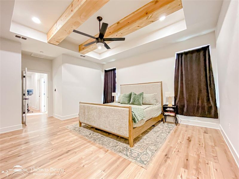 Primary bedroom with wooden beams and plentiful space.