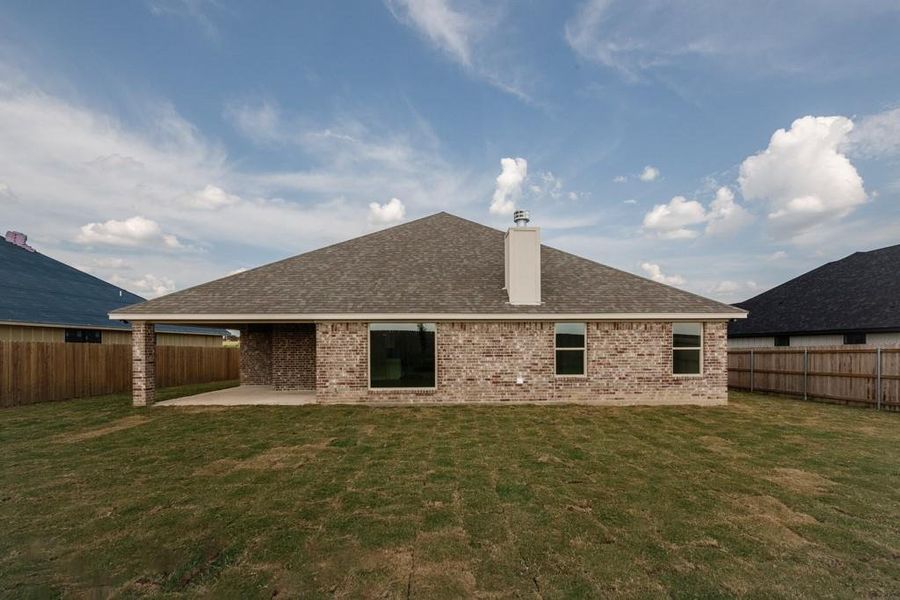 Rear view of house with a chimney, a patio, brick siding, and a fenced backyard Rear view of house with a chimney, a patio, brick siding, and a fenced backyard