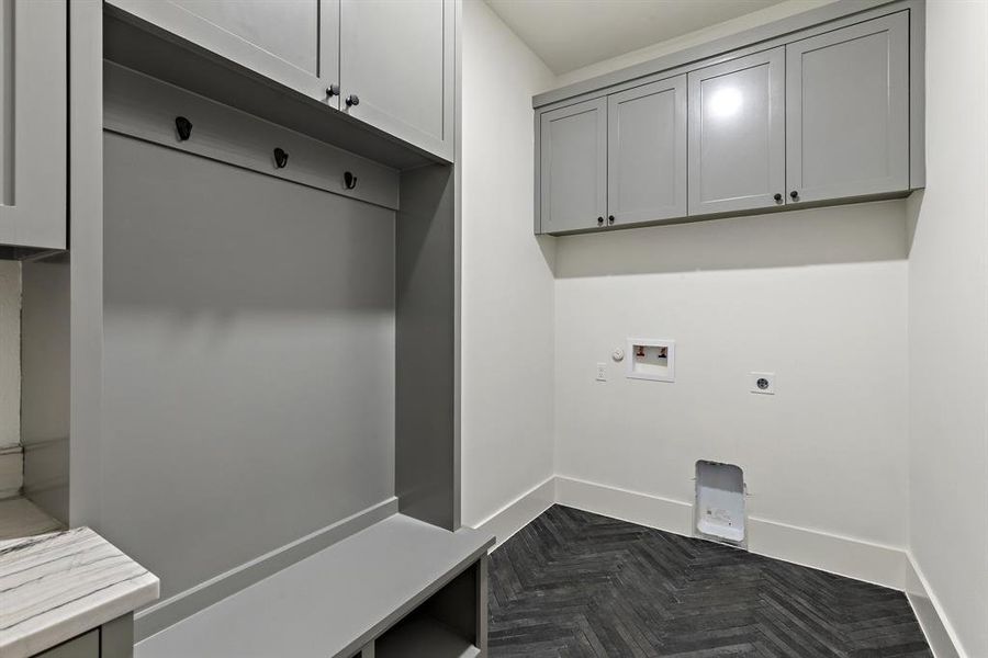 Laundry room / Mud room featuring hookup for a washing machine, cabinets, dark parquet floors, and electric dryer hookup