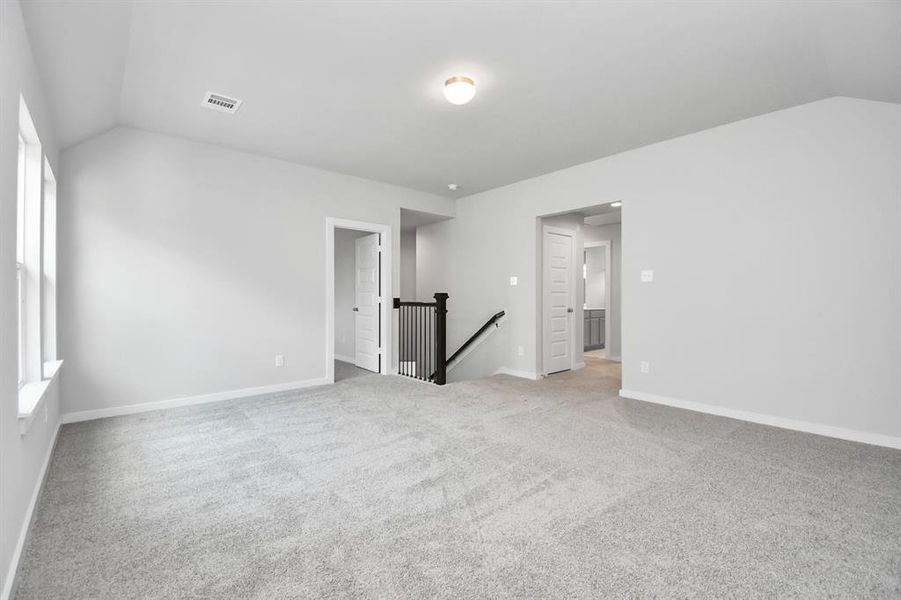 Ascend to relaxation in this fantastic game room! Ideal for both casual gatherings and adult gaming, it boasts plush carpet, lofty ceilings, custom paint, and ample windows for abundant natural light. Sample photo of completed home with same plan. Actual colors and selections may vary.