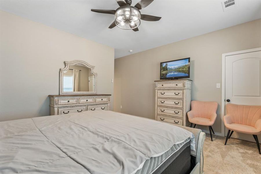 Bedroom featuring light carpet and ceiling fan Bedroom featuring light carpet and ceiling fan