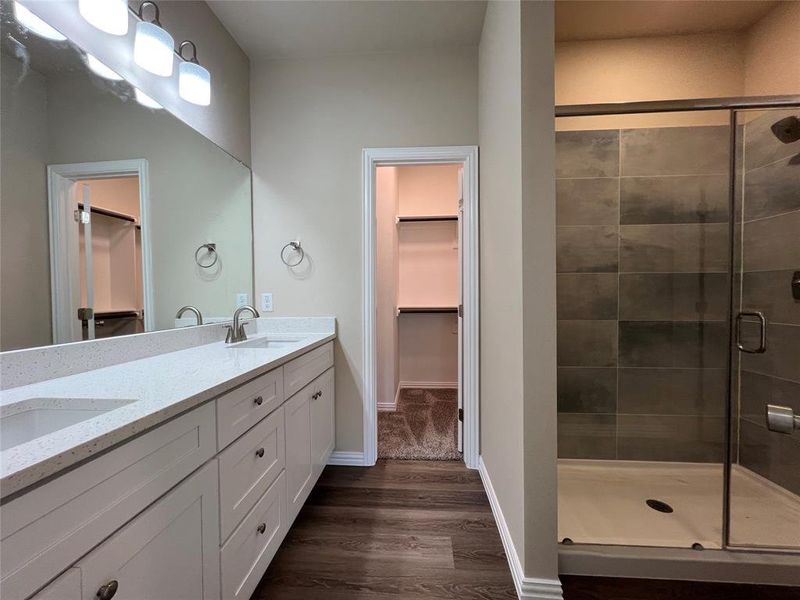 Bathroom with vanity, an enclosed shower, and hardwood / wood-style flooring