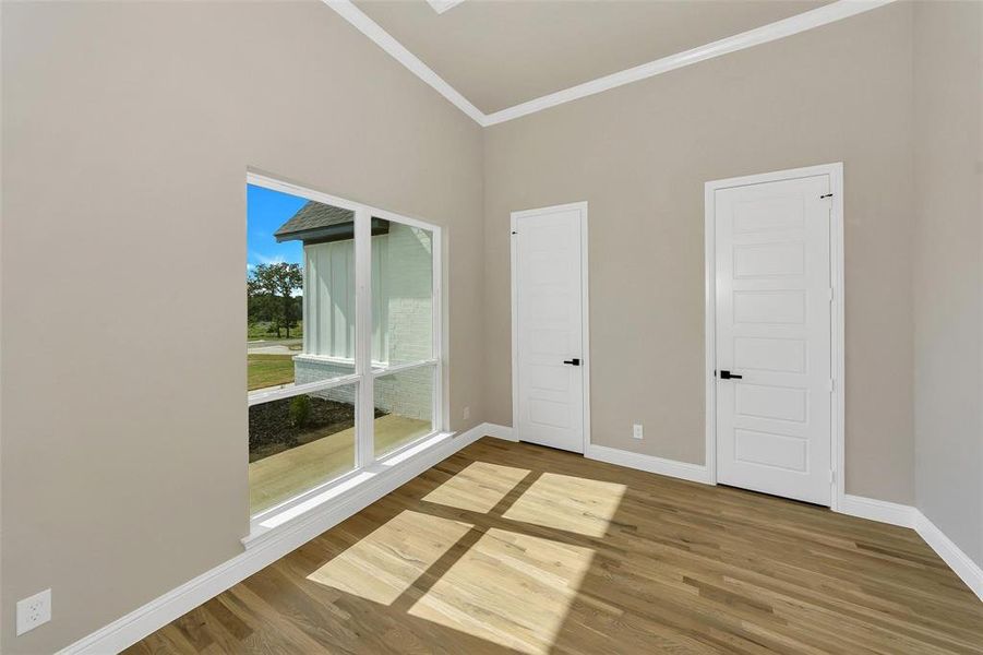 Spare room with ornamental molding and wood finished floors