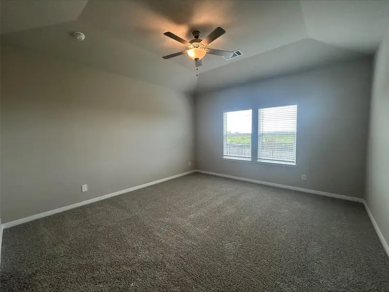 Carpeted spare room featuring ceiling fan and vaulted ceiling Carpeted spare room featuring ceiling fan and vaulted ceiling