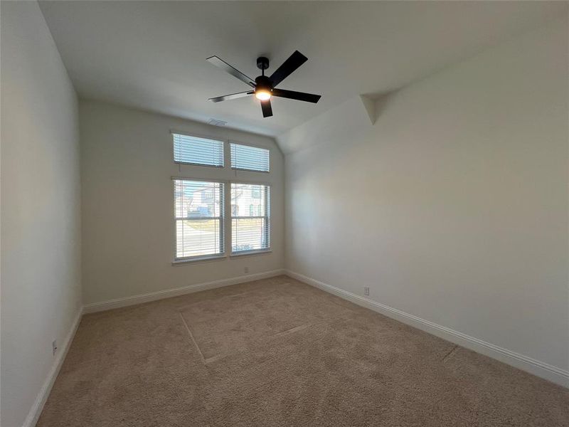 On-suite bedroom featuring ceiling fan, walk-in closet, and carpet flooring On-suite bedroom featuring ceiling fan, walk-in closet, and carpet flooring