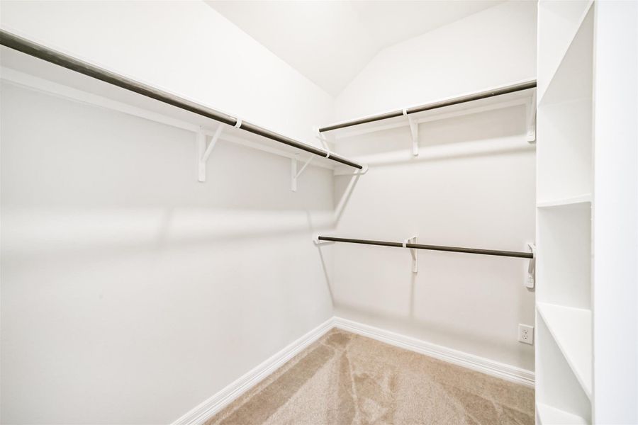 The spacious walk in closet offers ample shelving and hanging racks along with plush carpet, providing the perfect space to organize a large wardrobe year round. The spacious walk in closet offers ample shelving and hanging racks along with plush carpet, providing the perfect space to organize a large wardrobe year round.