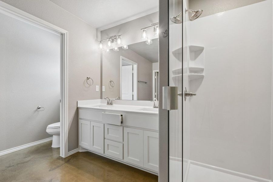 A well-lit bathroom features a double vanity and a convenient walk-in shower with a glass enclosure. A well-lit bathroom features a double vanity and a convenient walk-in shower with a glass enclosure.