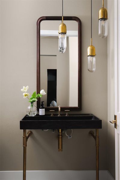 Elevated guest powder room. Tucked away for privacy from the main great room, this half bathroom features premium finishes that mirror the home’s overall aesthetic.
