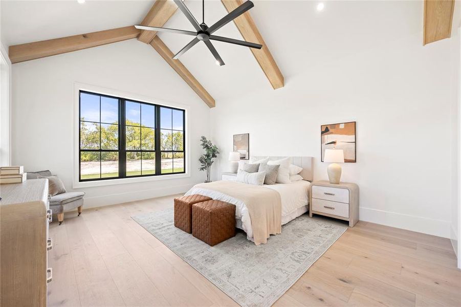 Bedroom with high vaulted ceiling, beam ceiling, light wood-style floors, and a ceiling fan