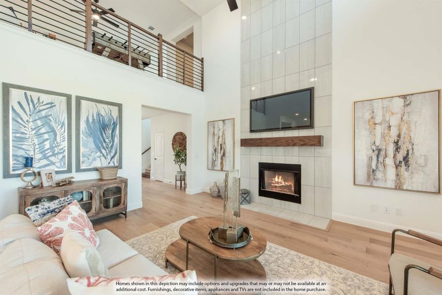 Two-story living room with tile fireplace, wood floors, and open loft railing above