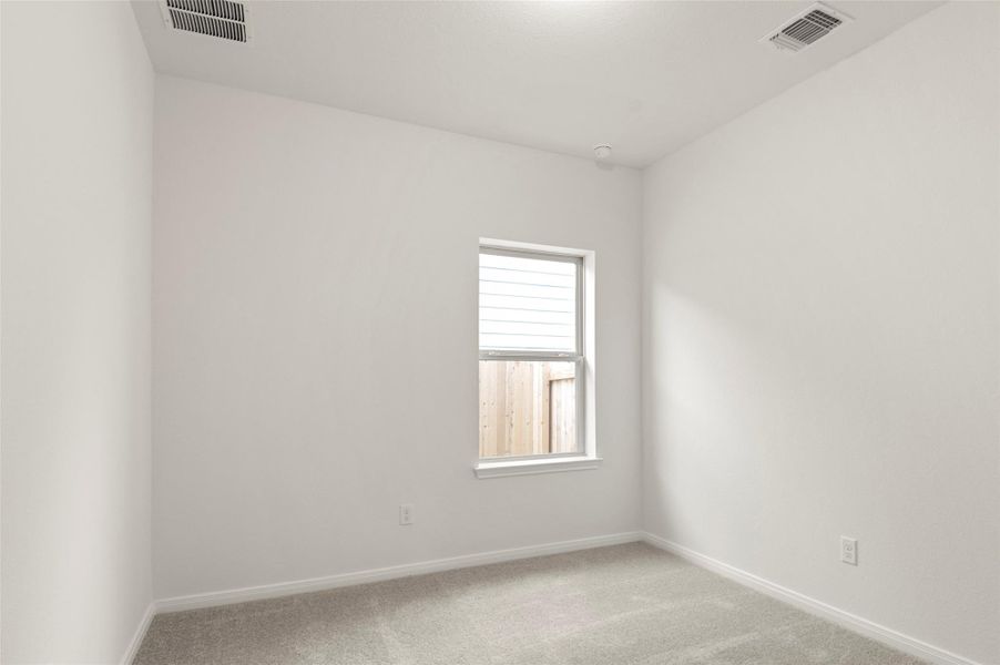 Spare room featuring light carpet and baseboards