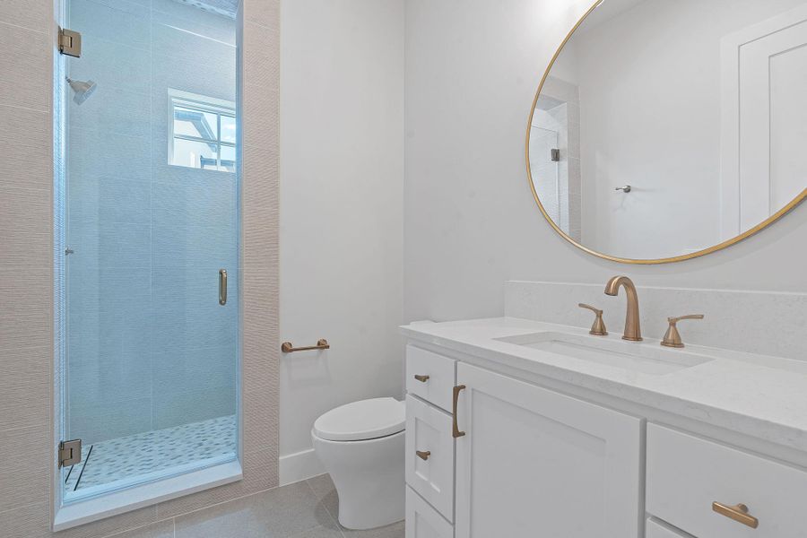Full bath with tile patterned flooring, vanity, toilet, and a walk-in shower. Full bath with tile patterned flooring, vanity, toilet, and a walk-in shower.
