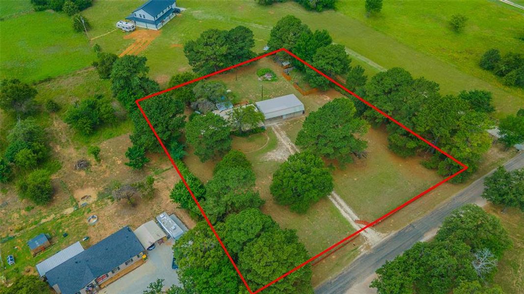Aerial view highlighting the home's acreage, mature trees, workshop, and peaceful rural setting. Aerial view highlighting the home's acreage, mature trees, workshop, and peaceful rural setting.