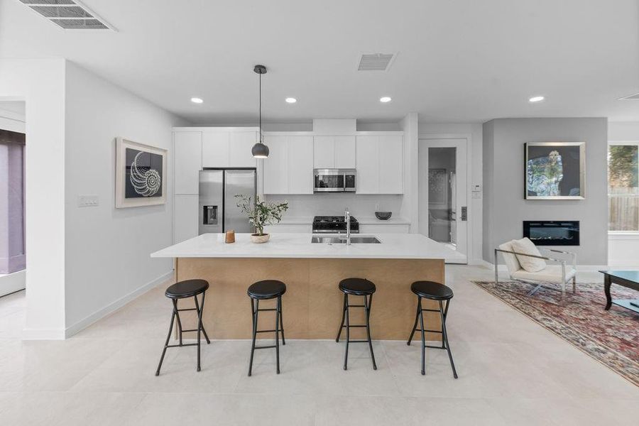 Sleek, modern kitchen featuring stainless steel Samsung appliances, slim shaker cabinetry, and a spacious island with trash/recycling drawer. Great for entertaining  and cooking.