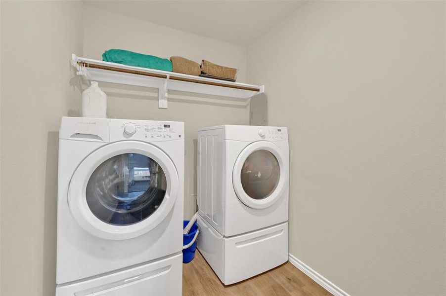 Laundry room with light wood-type flooring and washer and dryer