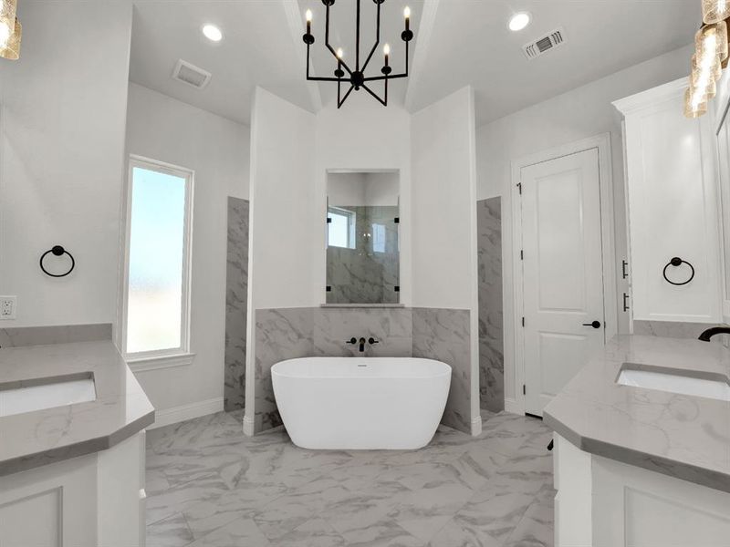 Bathroom featuring separate shower and tub, a wealth of natural light, vanity, and an inviting chandelier