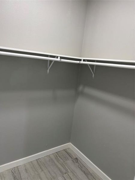 Walk in closet with light wood-style flooring Walk in closet with light wood-style flooring