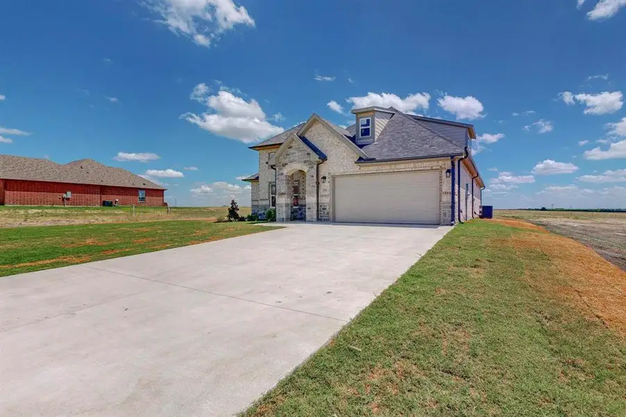 View of front facade featuring a garage and a front yard